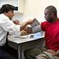 A GP checking a man's blood pressure