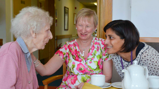 CQC team member is talking with two older women in a care home