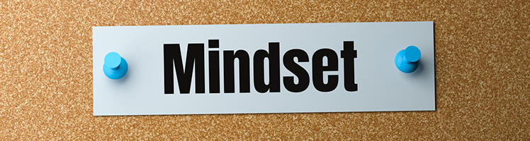 A mindset sticky note stuck on a corkboard.